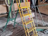 a yellow ladder that is next to a pile of wood