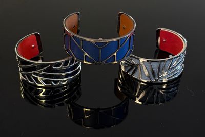 trois bracelets de couleurs différentes posés sur une surface noire
