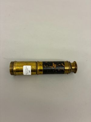 un télescope doré et noir posé sur une surface blanche