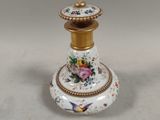 a small white and gold vase with flowers on it