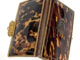 an image of a small tortoise shell box with a gold clasp