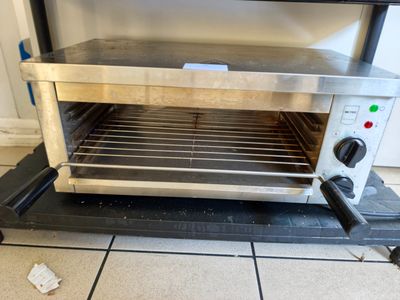 une photo d'un four grille-pain posé sur un sol carrelé