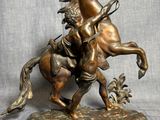 statue en bronze représentant un homme à cheval tenant un oiseau dans la main