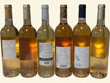 six bottles of white wine are lined up in a row