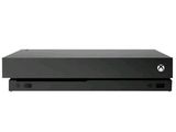 une console Xbox noire posée sur une surface blanche