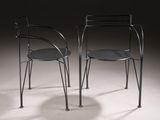 pair of black metal chairs sitting on top of a white floor