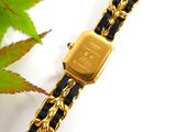 an image of a gold watch with a black and gold chain