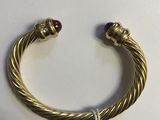 une image représentant un bracelet en or orné de grenats sur un fond blanc