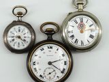 trois types différents de montres de poche sont présentés sur une surface blanche