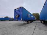 two blue trailers that are parked in a parking lot