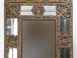 un vieux miroir avec un cadre en bois orné d'un motif floral