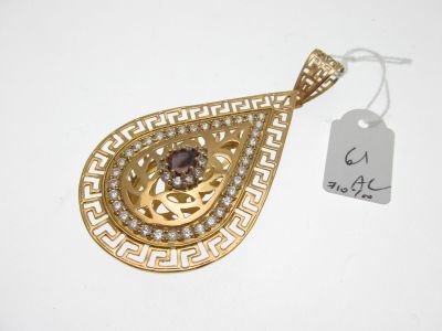 un gros plan d'un pendentif en or orné d'une pierre brune