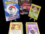 Trois cartes Pokémon sont posées les unes à côté des autres sur une table
