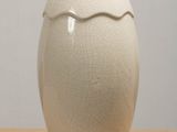a white vase sitting on top of a wooden table