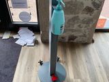 un vaporisateur bleu posé sur un support métallique