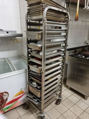 many trays of food sitting on a cart in the kitchen