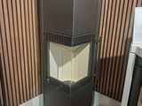 une armoire noire avec une porte vitrée, dans un coin de la pièce