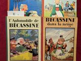 trois livres posés sur une table rouge