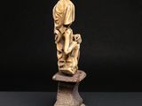 a carved statue of a woman holding a child on a pedestal