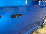a close up of a blue car with a sticker on it