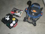 un aspirateur et d'autres outils posés par terre à côté de la porte de garage