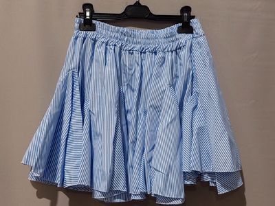 une jupe à rayures bleues et blanches suspendue à un cintre