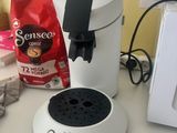 a white coffee maker sitting on a counter next to a microwave
