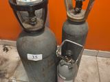 deux bouteilles de gaz propane posées l'une à côté de l'autre sur le sol
