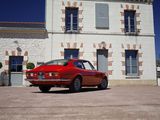 a red car parked in front of a white building