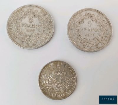 three different types of silver coins on a white surface
