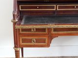 a small desk with a marble top and drawers on it