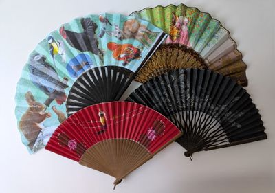de nombreux éventails de différentes couleurs sur un mur blanc