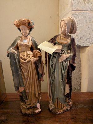 deux figurines représentant des femmes debout l'une à côté de l'autre sur une table