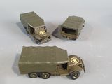 three toy army vehicles sitting on a white surface