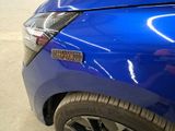a close up of a blue car parked in a parking lot