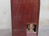 a small dog that is looking out of a wooden cabinet
