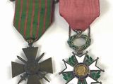deux médailles et une croix sont disposées sur un fond blanc
