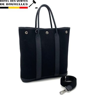 the black tote bag is next to a keychain on a white background