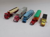plusieurs camions jouets sont alignés sur une surface blanche