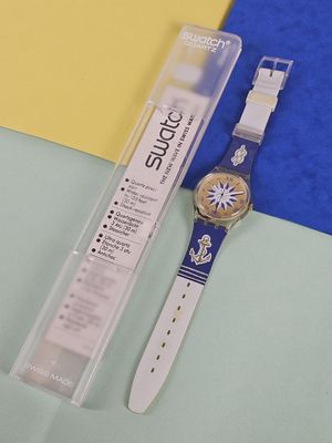 a watch sitting next to a plastic box on a table