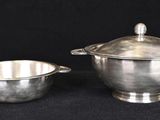 two pieces of silverware on a black background with a black background
