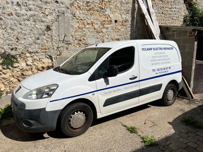 une camionnette blanche garée devant un mur de pierre
