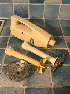 a yellow hand blender on a tiled floor next to a sink