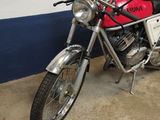 a red and black motorcycle parked next to a blue and white wall