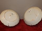 two white plates sitting on a red table cloth