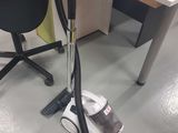 un aspirateur posé sur le sol à côté d'une chaise