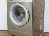 an image of a washing machine on wheels on a tiled floor