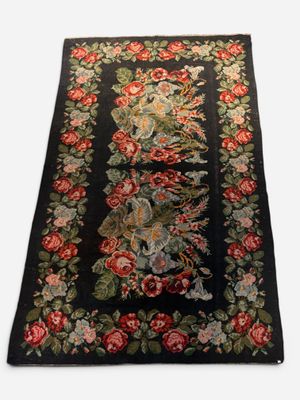 a close up of a black rug with red flowers on it