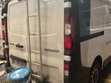 une camionnette garée dans un garage où se trouvent de nombreuses boîtes de peinture
