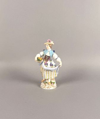 a small figurine of a woman with a basket of flowers